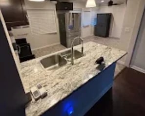 Modern bathroom vanity with granite countertop, dual sinks, and large mirror after renovation cleanup